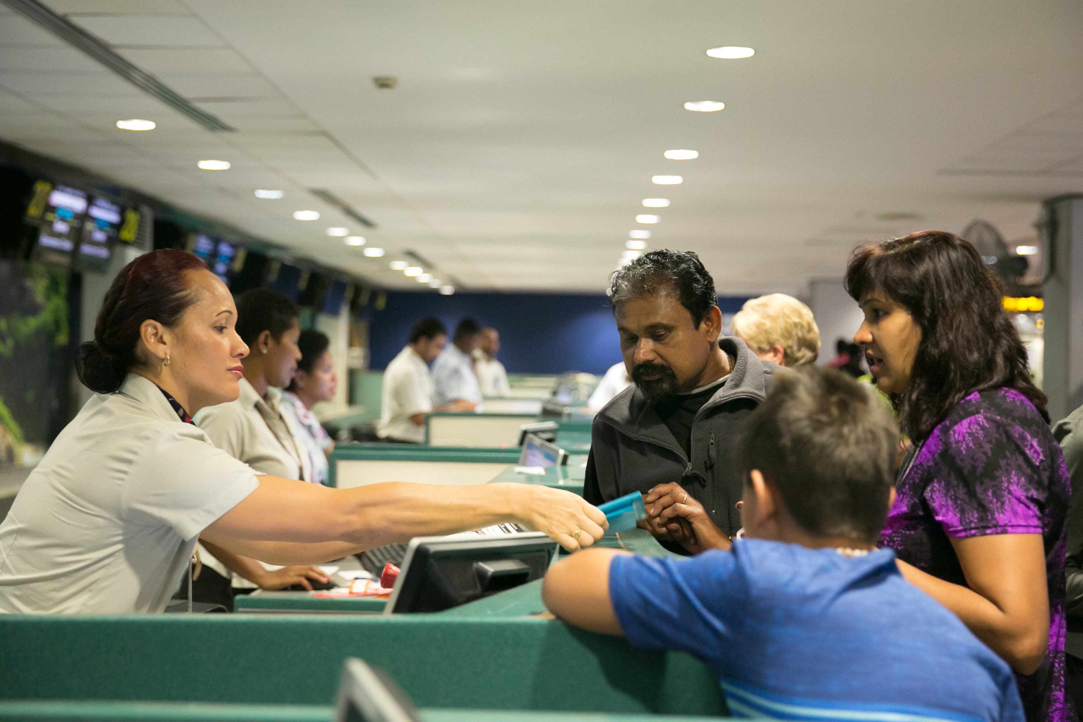 Passenger services staff assisting travellers at an airport check-in area
